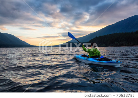 Beautiful View of Person Kayaking on Scenic Lake at Sunset 70638785