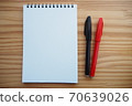 筆記本和簽字筆在木製辦公桌上排列（水平左邊緣） 70639026