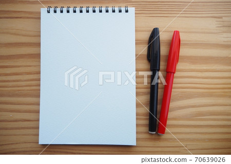 筆記本和簽字筆在木製辦公桌上排列（水平左邊緣） 70639026