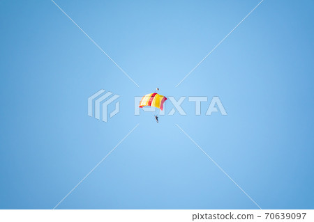 One parachutist floats slowly at low altitude on the background of clear sky One parachutist floats slowly at low altitude on the background of clear sky 70639097