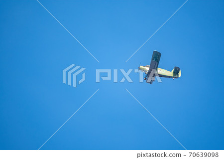 Retro green biplane plane in the blue sky Retro green biplane plane in the blue sky 70639098