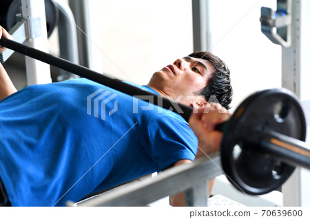 A man giving a bench press at the gym A man giving a bench press at the gym 70639600