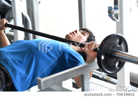A man giving a bench press at the gym A man giving a bench press at the gym 70639602