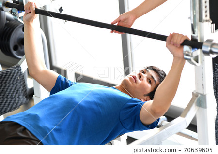 A man giving a bench press at the gym A man giving a bench press at the gym 70639605