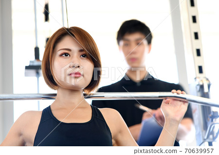 年輕的女性和男性教練在健身房做緯度下拉列表 年輕的女性和男性教練在健身房做緯度下拉列表 70639957