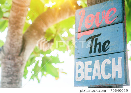 Love the beach word on wood board hang on tree beside summer beach. Love the beach word on wood board hang on tree beside summer beach. 70640029