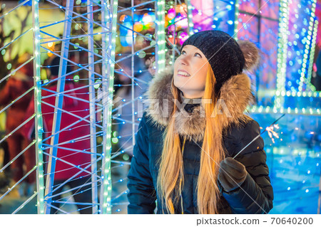 Portrait of young attractive celebrating woman holding sparkles. Crazy 2020 is over, it's 2021 70640200