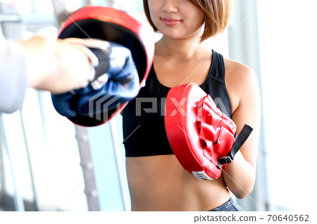 Young woman with a mitt in the gym Young woman with a mitt in the gym 70640562
