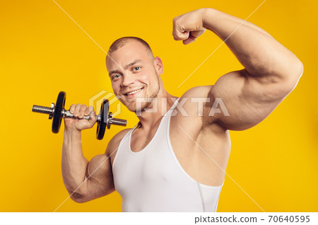 Studio portrait of muscular man with dumbbell Studio portrait of muscular man with dumbbell 70640595