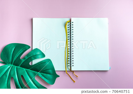 Top view of blank space white notebook and pen with tropical leaf as frame. 70640751