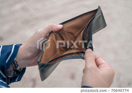 Woman holds an empty purse and coins in hand meaning money financial problem or bankrupt jobless, broke after credit card payday jobless. 70640774