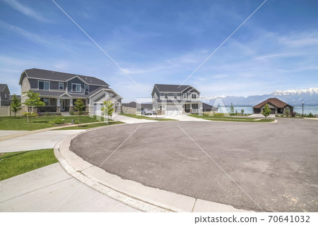 Peaceful neighborhood with scenic view of lake and mountain under blue sky Peaceful neighborhood with scenic view of lake and mountain under blue sky 70641032