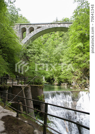 Vintgar mountains, river goes through bridge, waterfall. Spring time in Slovenia, Bled. Vintgar mountains, river goes through bridge, waterfall. Spring time in Slovenia, Bled. 70641348