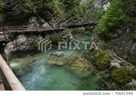 Clean river water goes through mountains, wooden bridges around. Slovenia, Vintgar gore near lake Bled. Clean river water goes through mountains, wooden bridges around. Slovenia, Vintgar gore near lake Bled. 70641349