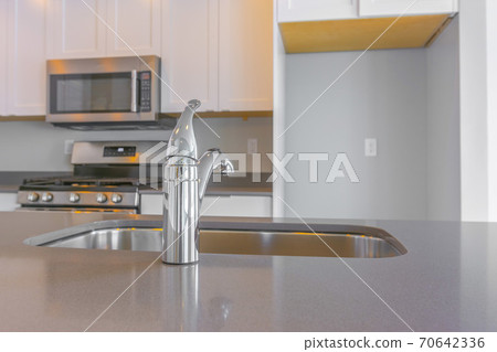 Modern kitchen interior with close up on the shiny faucet and sink 70642336
