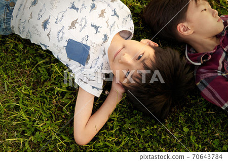 Boy lying on the grass 70643784