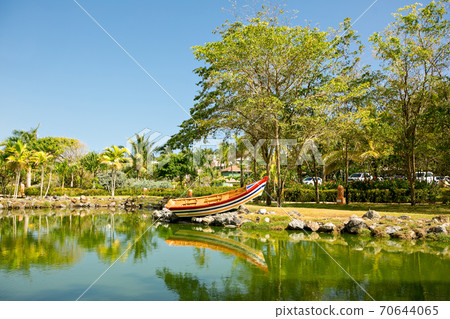 pond with boat surrounded by gardens in tropical. pond with boat surrounded by gardens in tropical. 70644065