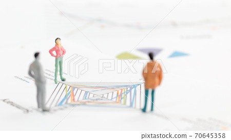 Miniature figures businessman standing on a graph chart Miniature figures businessman standing on a graph chart 70645358