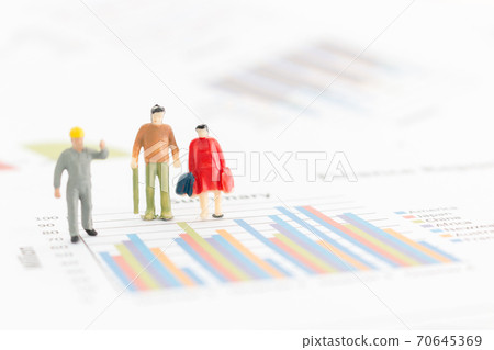 Miniature figures businessman standing on a graph chart Miniature figures businessman standing on a graph chart 70645369