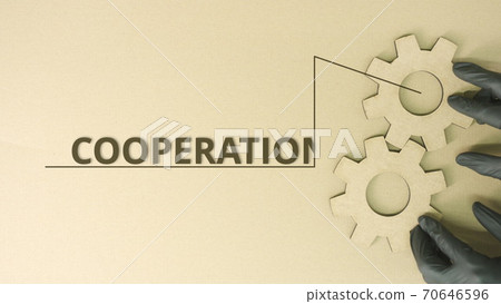 Cooperation text at cogwheels made from recycled cardboard 70646596
