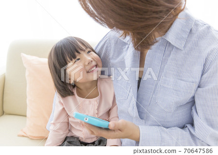 Parent and child seeing smartphone Parent and child seeing smartphone 70647586