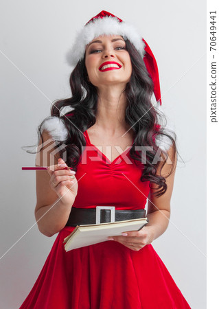 Santa girl with wish list and pencil Santa girl with wish list and pencil 70649441