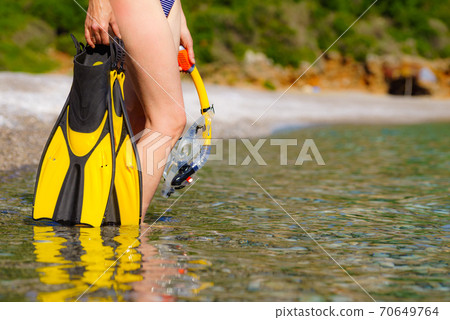 Woman with flippers snorkeling tube on beach 70649764