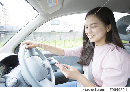 Woman driving while Woman driving while 70649834