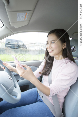 Woman driving while Woman driving while 70649836