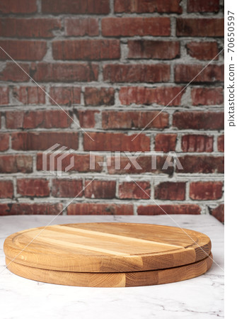 empty round wooden cutting board against brown brick wall background empty round wooden cutting board against brown brick wall background 70650597
