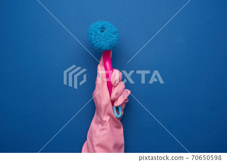 hand in a pink rubber glove for cleaning a house holds plastic brush with a handle hand in a pink rubber glove for cleaning a house holds plastic brush with a handle 70650598