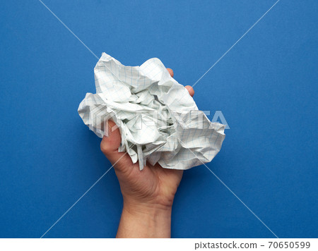 woman holds in her hand a crumpled sheet of paper woman holds in her hand a crumpled sheet of paper 70650599