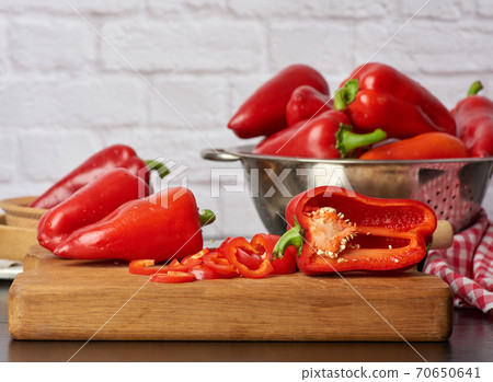 sliced red pepper on a cutting wooden board 70650641