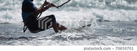 Athletic man jump on kite surf board on a sea waves 70650701