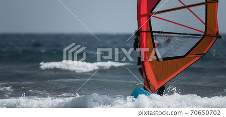 Windsurfer surfing the wind on waves in ocean sea 70650702