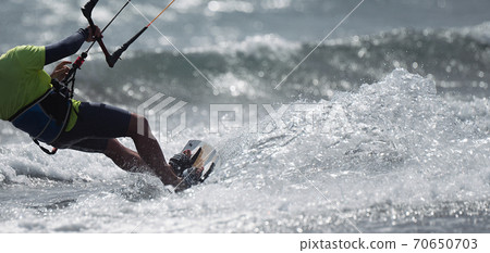 Athletic man jump on kite surf board on a sea waves 70650703