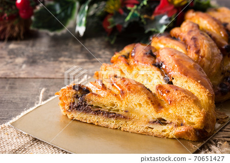 Homemade braid stuffed with chocolate and cut into pieces on wooden table. 70651427