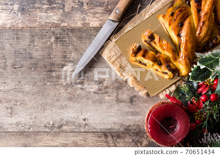 Homemade braid stuffed with chocolate and cut into pieces on wooden table. 70651434