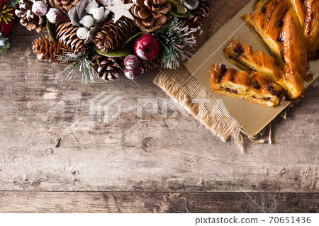 Homemade braid stuffed with chocolate and cut into pieces on wooden table. 70651436