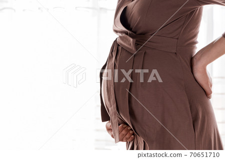 Pregnant mother get painful of back and touching her back in bedroom at home standing near window . Pregnancy healthcare concept Pregnant mother get painful of back and touching her back in bedroom at home standing near window . Pregnancy healthcare concept 70651710