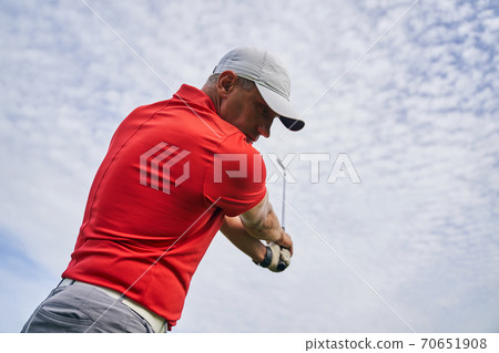 Professional male athlete improving his golf upswing Professional male athlete improving his golf upswing 70651908