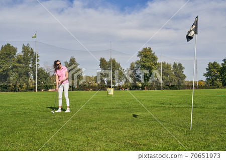 Professional Caucasian female player putting a ball 70651973
