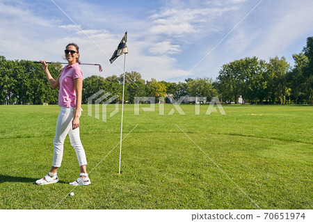 Joyous golf player standing near the flagstick 70651974