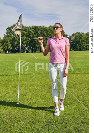 Thoughtful sportswoman with a club staring away 70652009