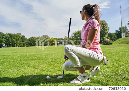 Golfer in sunglasses looking into the distance 70652010