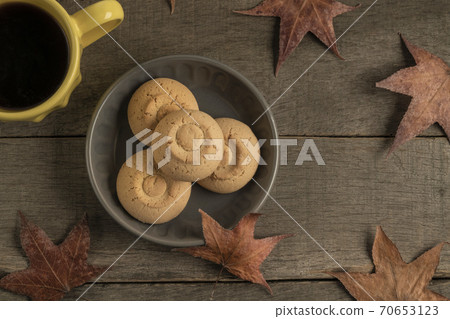 cup of coffee and cookies on a wooden table decorated dried autumn leaves cup of coffee and cookies on a wooden table decorated dried autumn leaves 70653123
