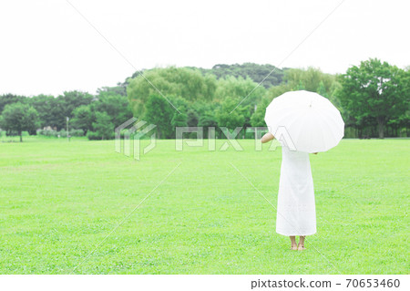 Back view of a woman holding a parasol Back view of a woman holding a parasol 70653460
