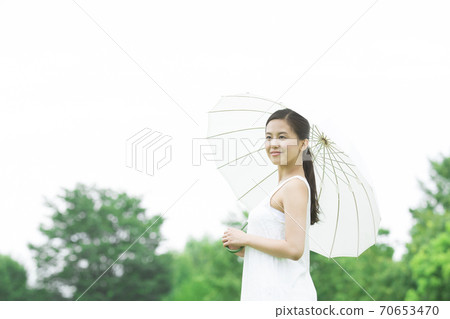 A woman holding a parasol 70653470