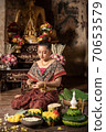 Thai girl in traditional dress costume making and decorating Krathong. Loy Krathong Festival. 70653579