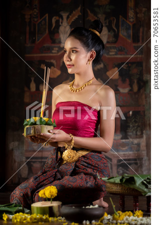 Thai girl in traditional dress costume making and decorating Krathong. Loy Krathong Festival. 70653581